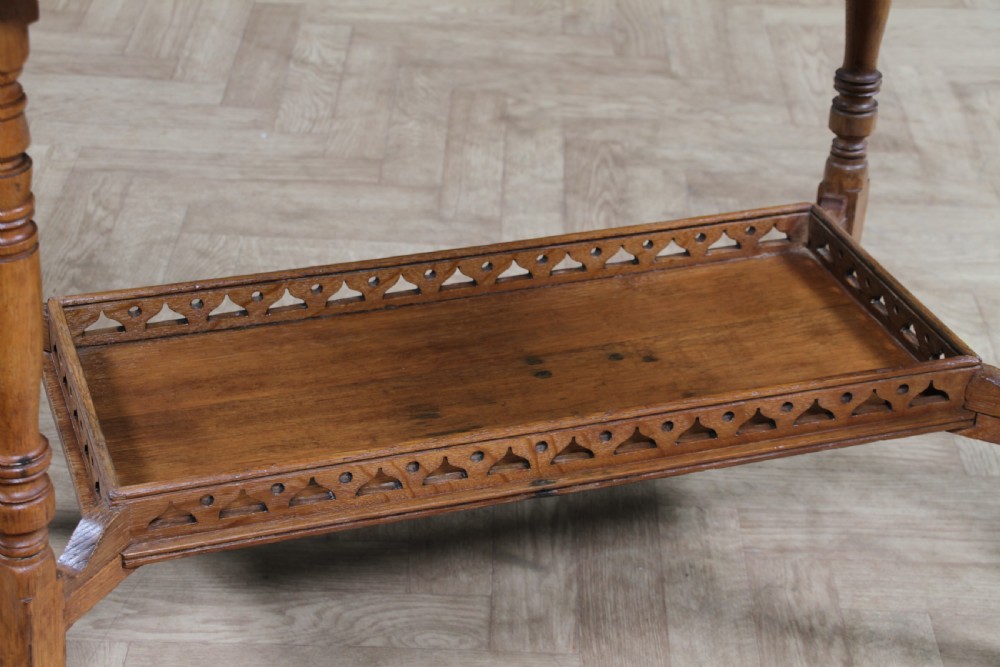 An Edwardian golden oak side table featuring a rectangular top, turned support legs, and a lower undertier shelf with a pierced cut-out gallery rail. View III