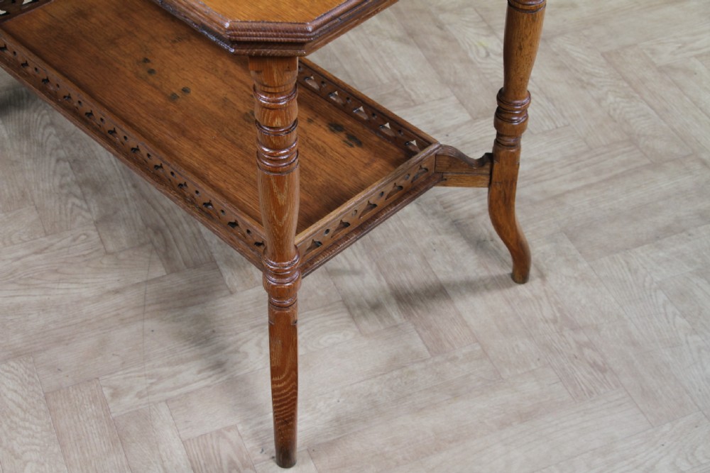 An Edwardian golden oak side table featuring a rectangular top, turned support legs, and a lower undertier shelf with a pierced cut-out gallery rail. View V