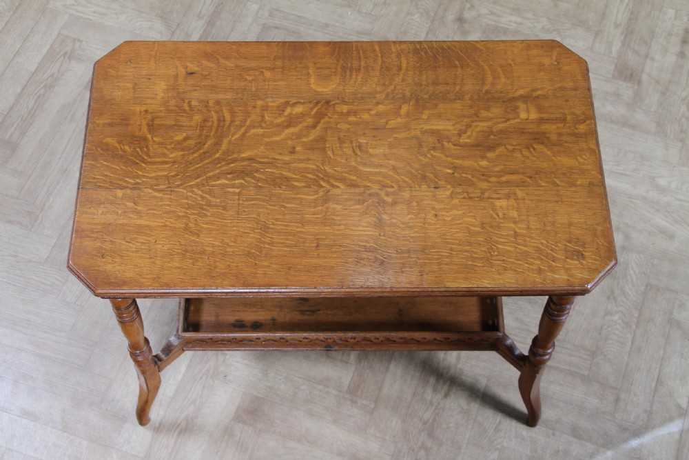 An Edwardian golden oak side table featuring a rectangular top, turned support legs, and a lower undertier shelf with a pierced cut-out gallery rail. View VII