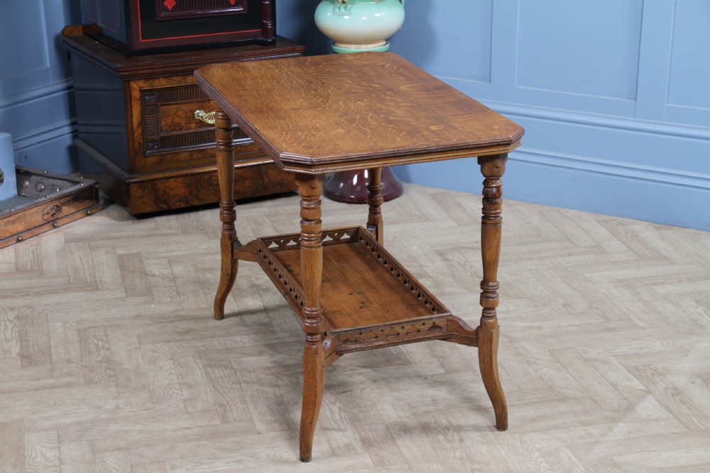 An Edwardian golden oak side table featuring a rectangular top, turned support legs, and a lower undertier shelf with a pierced cut-out gallery rail. View VIII