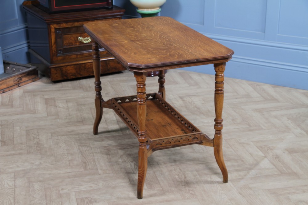 An Edwardian golden oak side table featuring a rectangular top, turned support legs, and a lower undertier shelf with a pierced cut-out gallery rail. View X