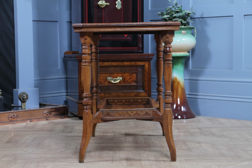 An Edwardian golden oak side table featuring a rectangular top, turned support legs, and a lower undertier shelf with a pierced cut-out gallery rail. View XIII