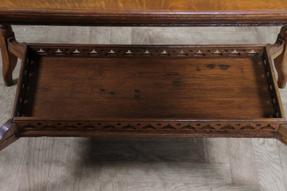 An Edwardian golden oak side table featuring a rectangular top, turned support legs, and a lower undertier shelf with a pierced cut-out gallery rail. View XIV