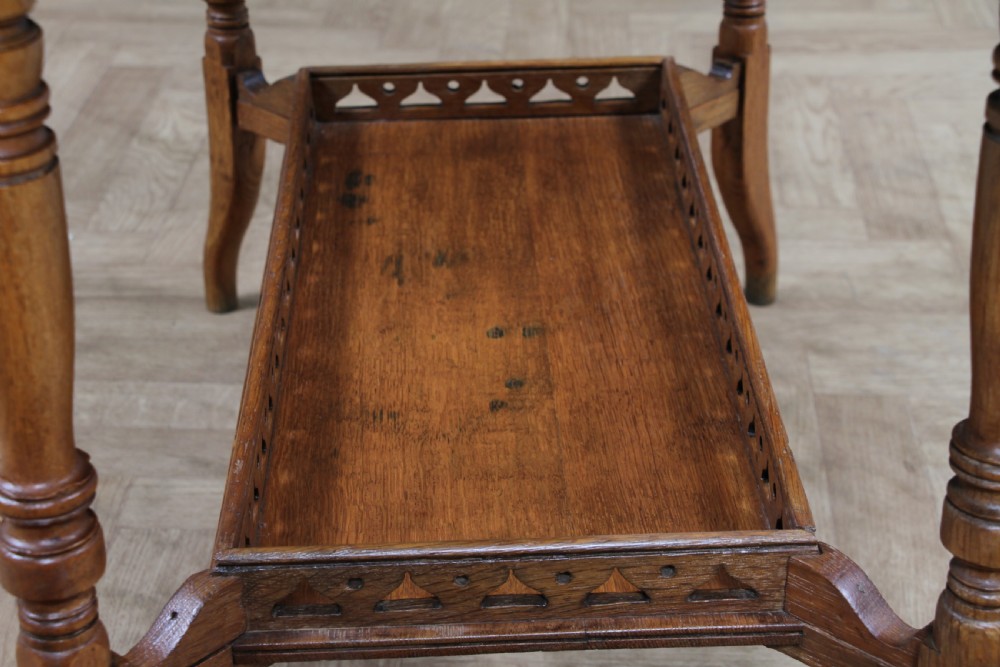 An Edwardian golden oak side table featuring a rectangular top, turned support legs, and a lower undertier shelf with a pierced cut-out gallery rail. View XV