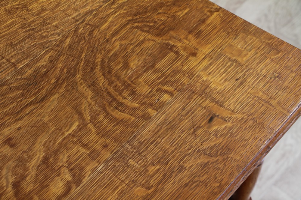 An Edwardian golden oak side table featuring a rectangular top, turned support legs, and a lower undertier shelf with a pierced cut-out gallery rail. View XVI
