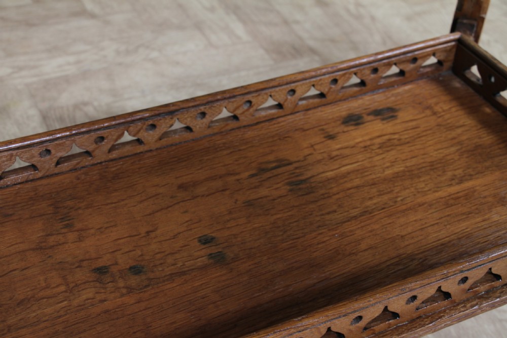 An Edwardian golden oak side table featuring a rectangular top, turned support legs, and a lower undertier shelf with a pierced cut-out gallery rail. View XVIII