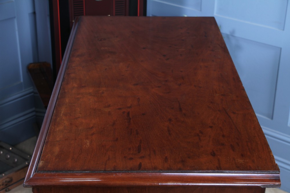 An antique Victorian flame mahogany chest of drawers featuring two short over three long drawers with turned wooden handles on a solid plinth base. View VII