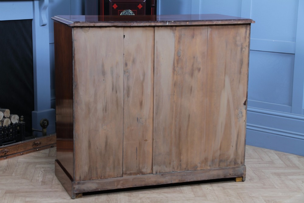 An antique Victorian flame mahogany chest of drawers featuring two short over three long drawers with turned wooden handles on a solid plinth base. View XXII