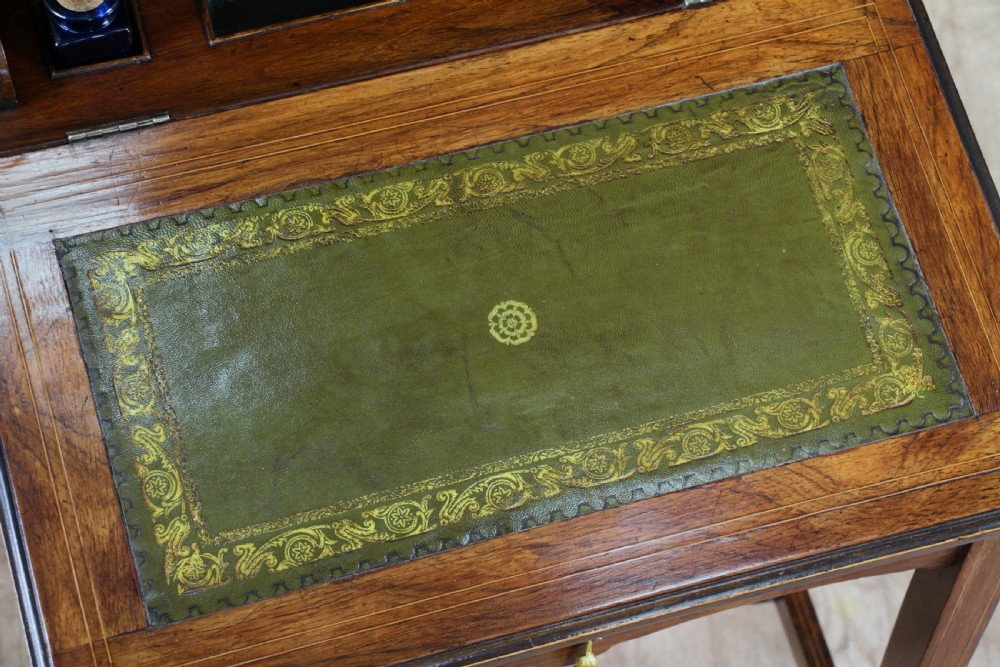 A late Victorian inlaid rosewood bonheur du jour writing desk featuring a green leather surface, raised gallery shelf, and tapered legs with brass castors. View V