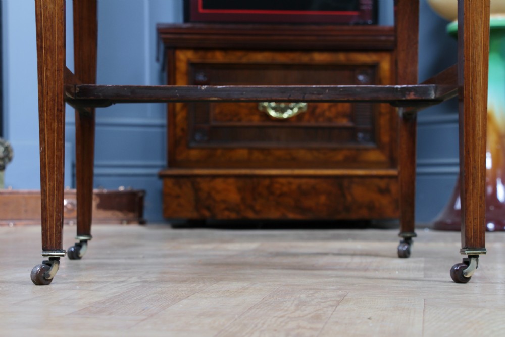 A late Victorian inlaid rosewood bonheur du jour writing desk featuring a green leather surface, raised gallery shelf, and tapered legs with brass castors. View XVIII