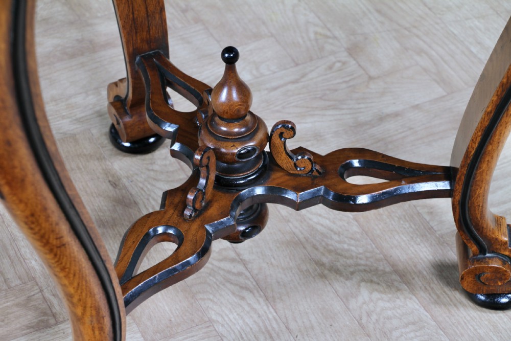 A Victorian Aesthetic Movement oak handkerchief table featuring ebonised accents, curved legs, and a triangular drop-leaf top with a central inlaid floral motif. View XIII