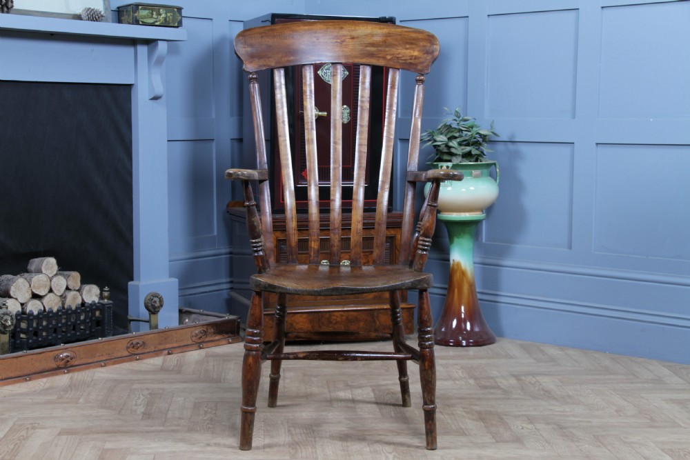 An antique Victorian lathe back armchair crafted from warm brown timber with turned legs and a solid shaped seat. View II