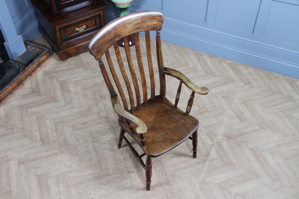 An antique Victorian lathe back armchair crafted from warm brown timber with turned legs and a solid shaped seat. View III
