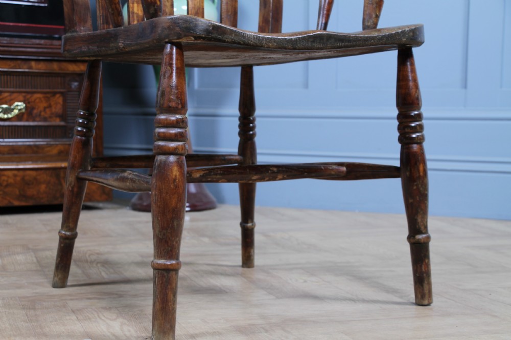 An antique Victorian lathe back armchair crafted from warm brown timber with turned legs and a solid shaped seat. View VII