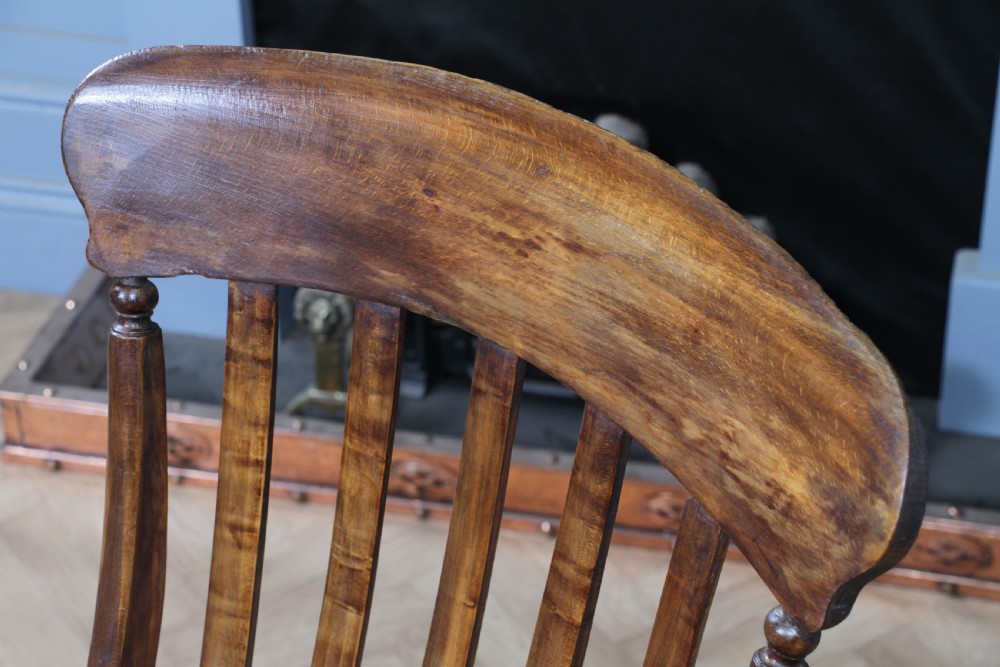 An antique Victorian lathe back armchair crafted from warm brown timber with turned legs and a solid shaped seat. View IX