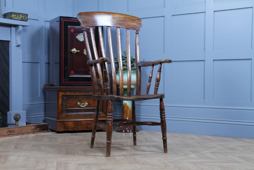 An antique Victorian lathe back armchair crafted from warm brown timber with turned legs and a solid shaped seat. View X