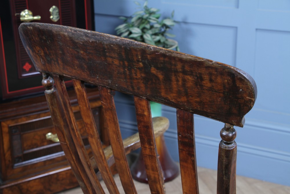 An antique Victorian lathe back armchair crafted from warm brown timber with turned legs and a solid shaped seat. View XV