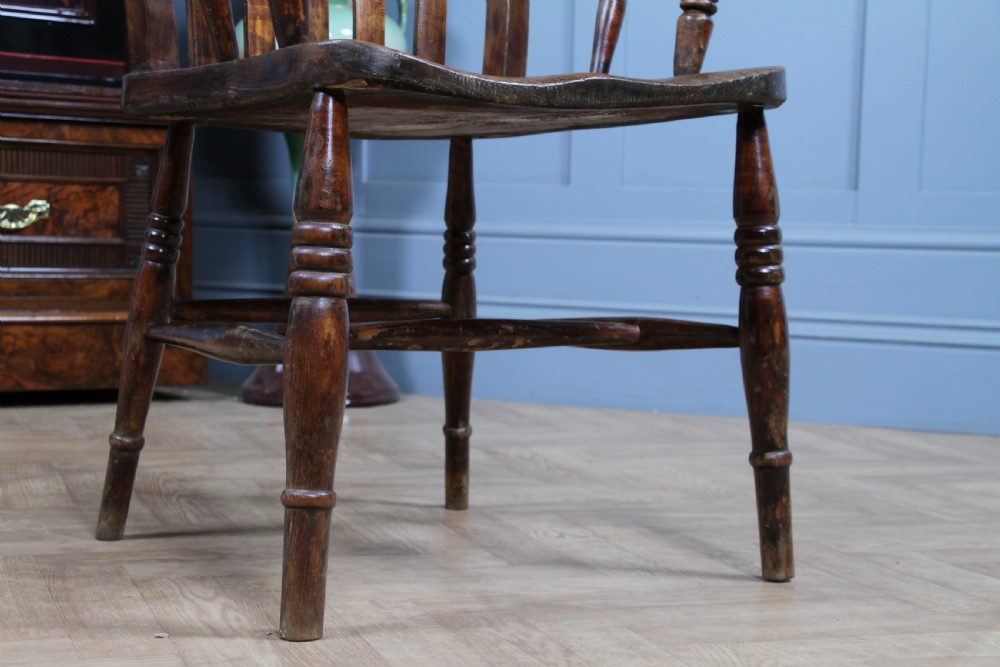 An antique Victorian lathe back armchair crafted from warm brown timber with turned legs and a solid shaped seat. View XVI