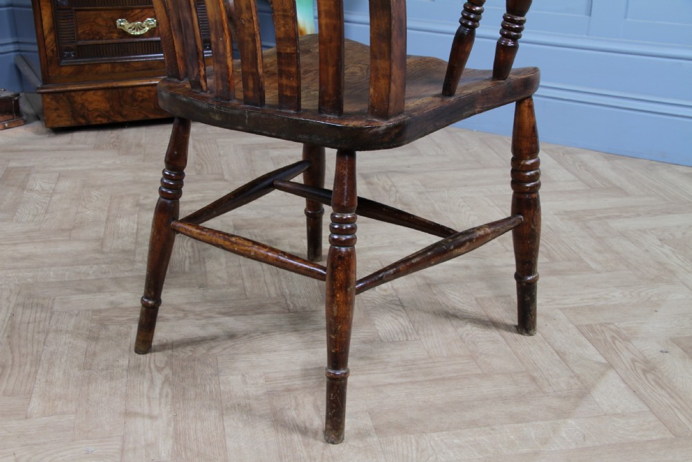 An antique Victorian lathe back armchair crafted from warm brown timber with turned legs and a solid shaped seat. View XVII
