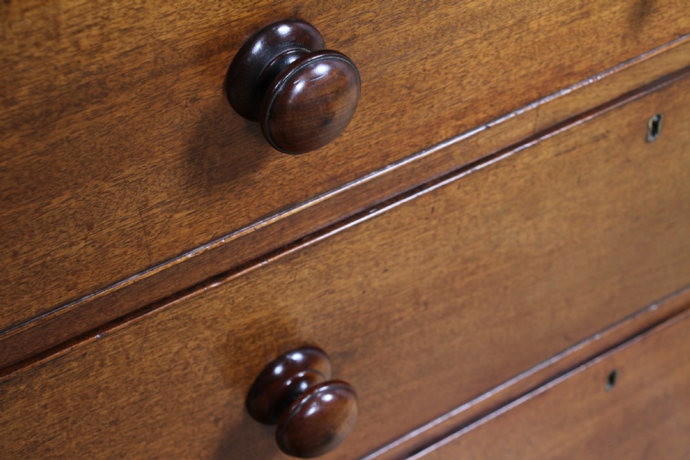 A restored Georgian mahogany chest of five drawers featuring two short drawers over three long drawers with turned wooden knobs and bracket feet. View VI