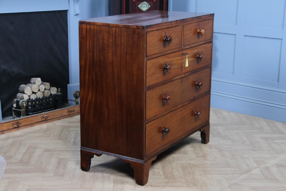 A restored Georgian mahogany chest of five drawers featuring two short drawers over three long drawers with turned wooden knobs and bracket feet. View VIII