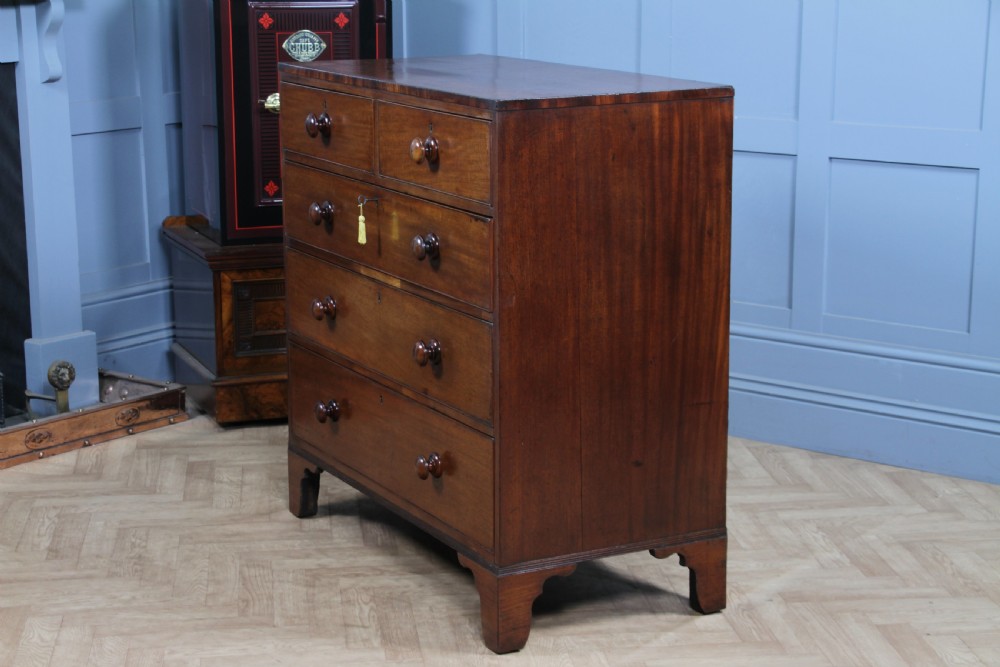 A restored Georgian mahogany chest of five drawers featuring two short drawers over three long drawers with turned wooden knobs and bracket feet. View IX