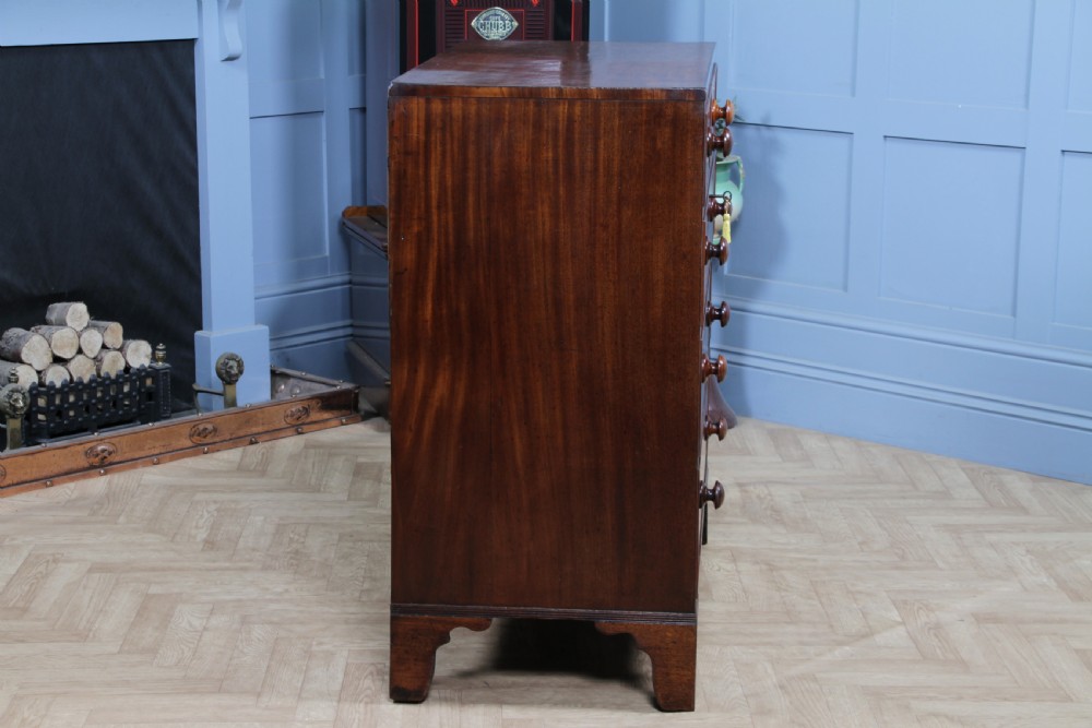 A restored Georgian mahogany chest of five drawers featuring two short drawers over three long drawers with turned wooden knobs and bracket feet. View X
