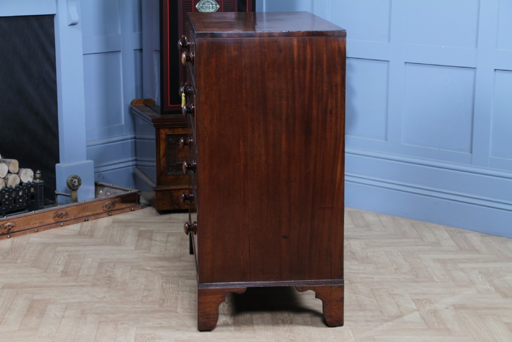 A restored Georgian mahogany chest of five drawers featuring two short drawers over three long drawers with turned wooden knobs and bracket feet. View XI