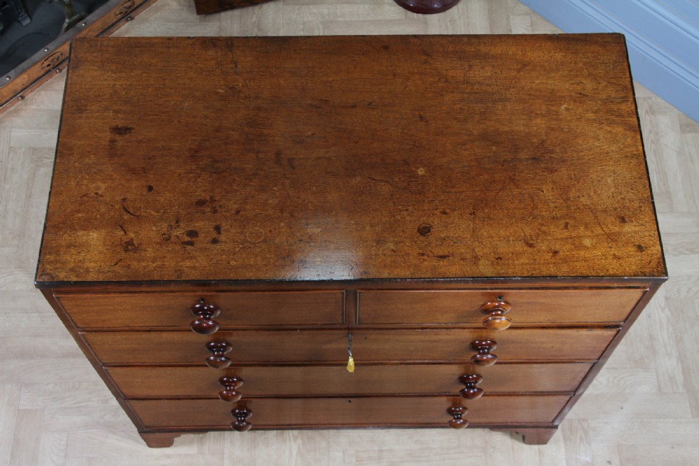 A restored Georgian mahogany chest of five drawers featuring two short drawers over three long drawers with turned wooden knobs and bracket feet. View XII