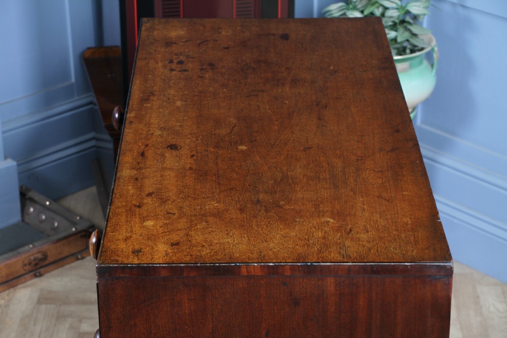 A restored Georgian mahogany chest of five drawers featuring two short drawers over three long drawers with turned wooden knobs and bracket feet. View XIII