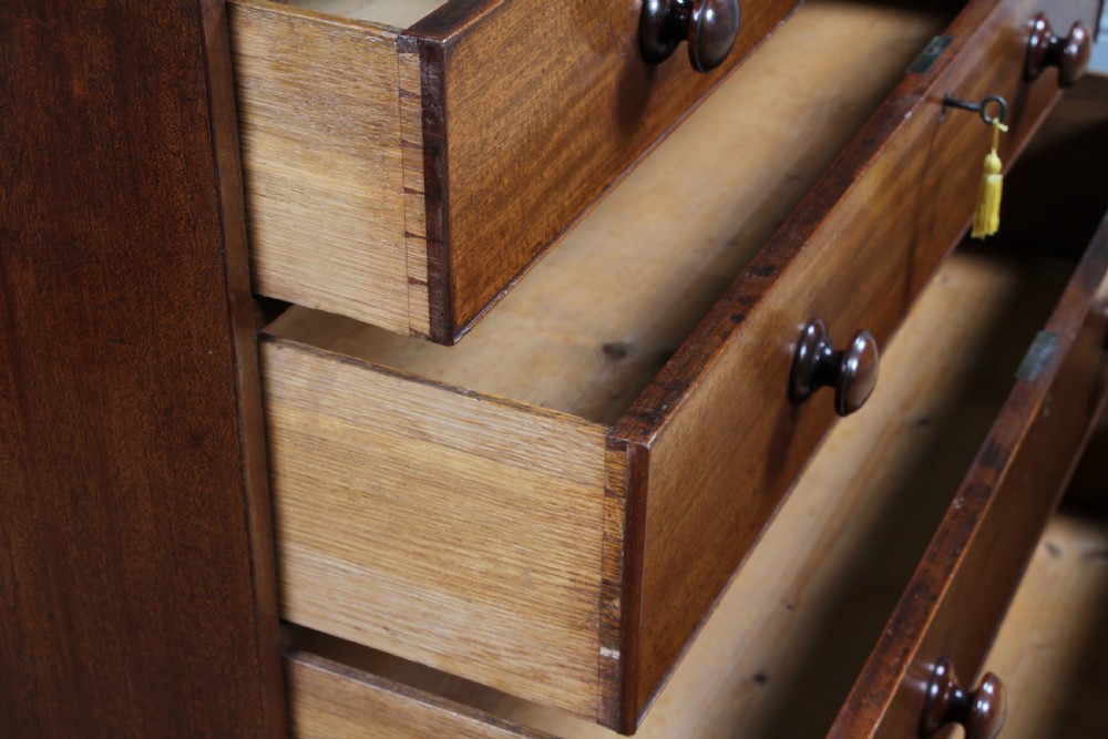 A restored Georgian mahogany chest of five drawers featuring two short drawers over three long drawers with turned wooden knobs and bracket feet. View XIV