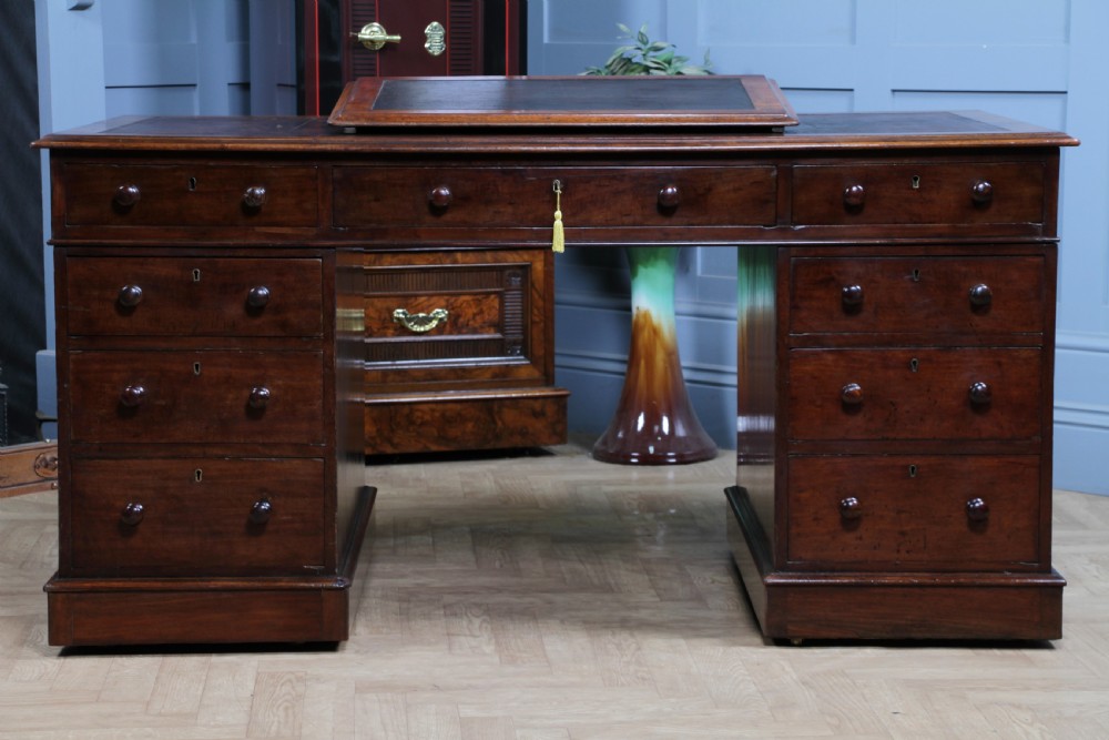 A Victorian mahogany pedestal desk featuring twin drawer pedestals, a dark leather writing inset, and a matching angled writing slope. View XIII