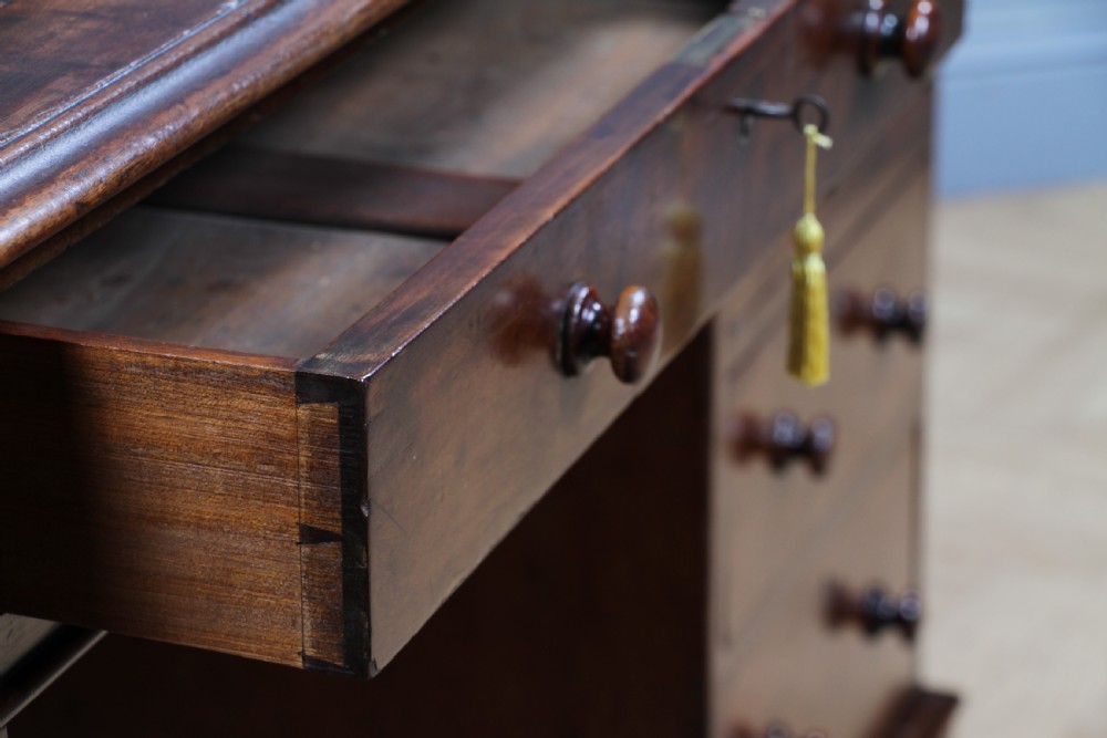 A Victorian mahogany pedestal desk featuring twin drawer pedestals, a dark leather writing inset, and a matching angled writing slope. View XIV