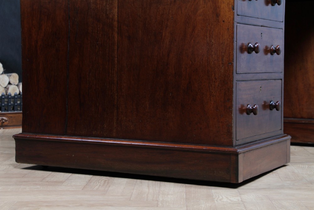 A Victorian mahogany pedestal desk featuring twin drawer pedestals, a dark leather writing inset, and a matching angled writing slope. View XVIII