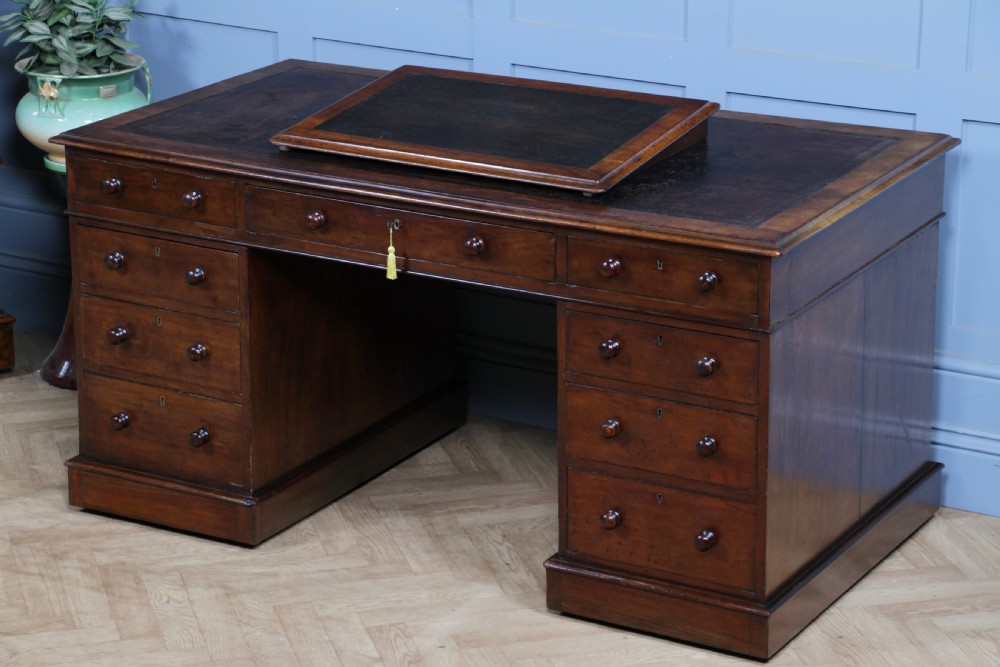 A Victorian mahogany pedestal desk featuring twin drawer pedestals, a dark leather writing inset, and a matching angled writing slope. View XIX