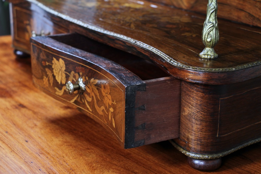 A French Napoleon III rosewood tabletop etagere featuring two tiered shelves decorated with floral marquetry, gilt metal mounts, a gallery rail, and two small base drawers. View III