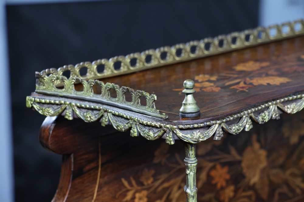 A French Napoleon III rosewood tabletop etagere featuring two tiered shelves decorated with floral marquetry, gilt metal mounts, a gallery rail, and two small base drawers. View IV