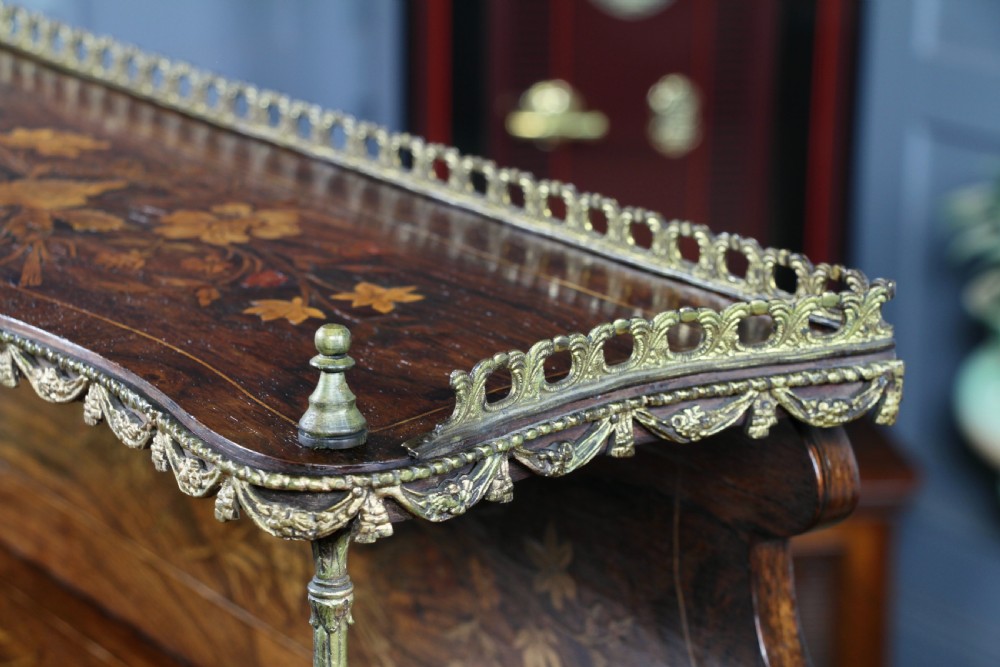 A French Napoleon III rosewood tabletop etagere featuring two tiered shelves decorated with floral marquetry, gilt metal mounts, a gallery rail, and two small base drawers. View V