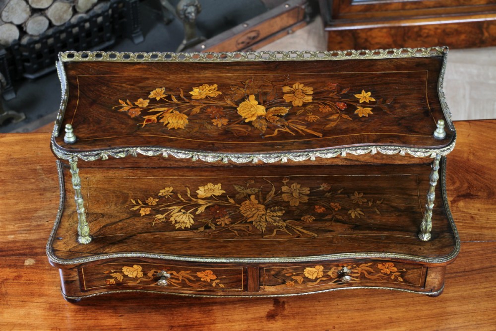A French Napoleon III rosewood tabletop etagere featuring two tiered shelves decorated with floral marquetry, gilt metal mounts, a gallery rail, and two small base drawers. View IX