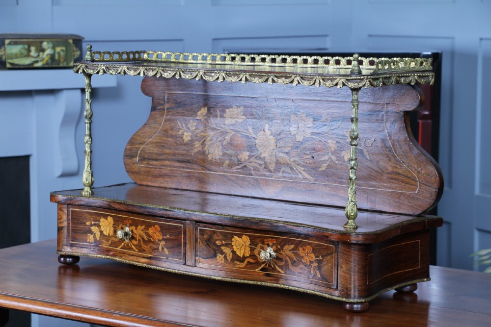 A French Napoleon III rosewood tabletop etagere featuring two tiered shelves decorated with floral marquetry, gilt metal mounts, a gallery rail, and two small base drawers. View XIV