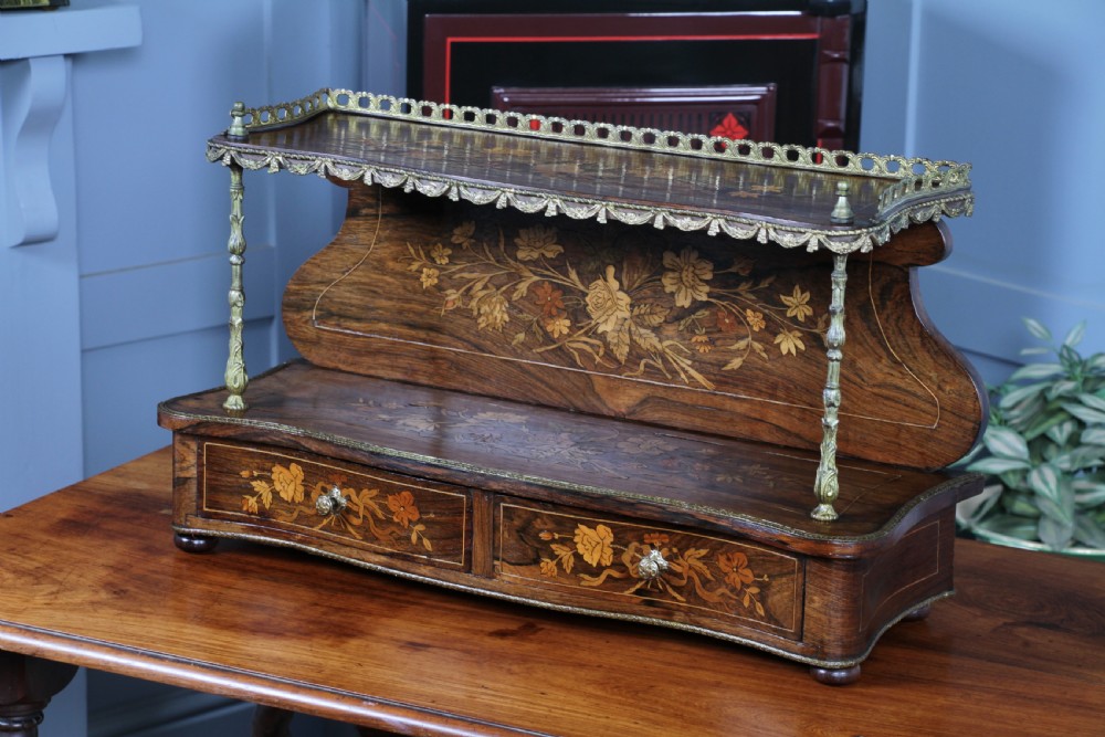 A French Napoleon III rosewood tabletop etagere featuring two tiered shelves decorated with floral marquetry, gilt metal mounts, a gallery rail, and two small base drawers. View XVI