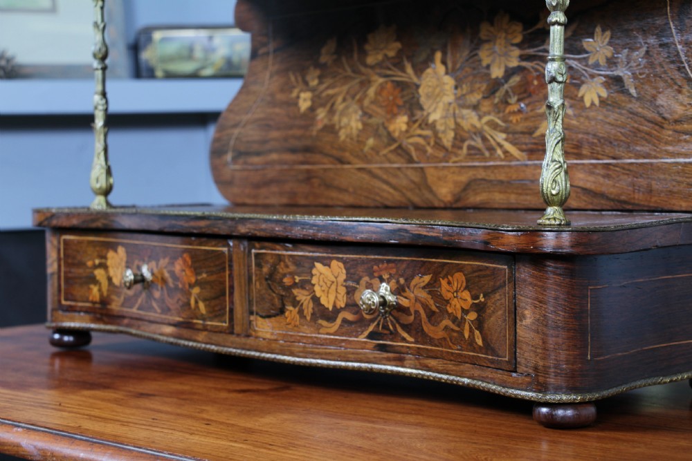 A French Napoleon III rosewood tabletop etagere featuring two tiered shelves decorated with floral marquetry, gilt metal mounts, a gallery rail, and two small base drawers. View XVIII