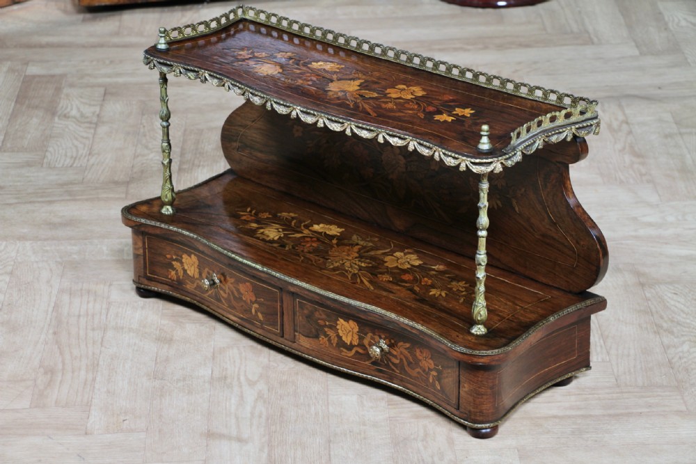 A French Napoleon III rosewood tabletop etagere featuring two tiered shelves decorated with floral marquetry, gilt metal mounts, a gallery rail, and two small base drawers. View XIX