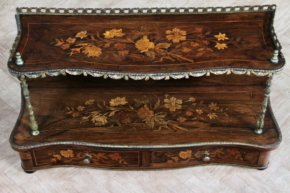 A French Napoleon III rosewood tabletop etagere featuring two tiered shelves decorated with floral marquetry, gilt metal mounts, a gallery rail, and two small base drawers. View XX