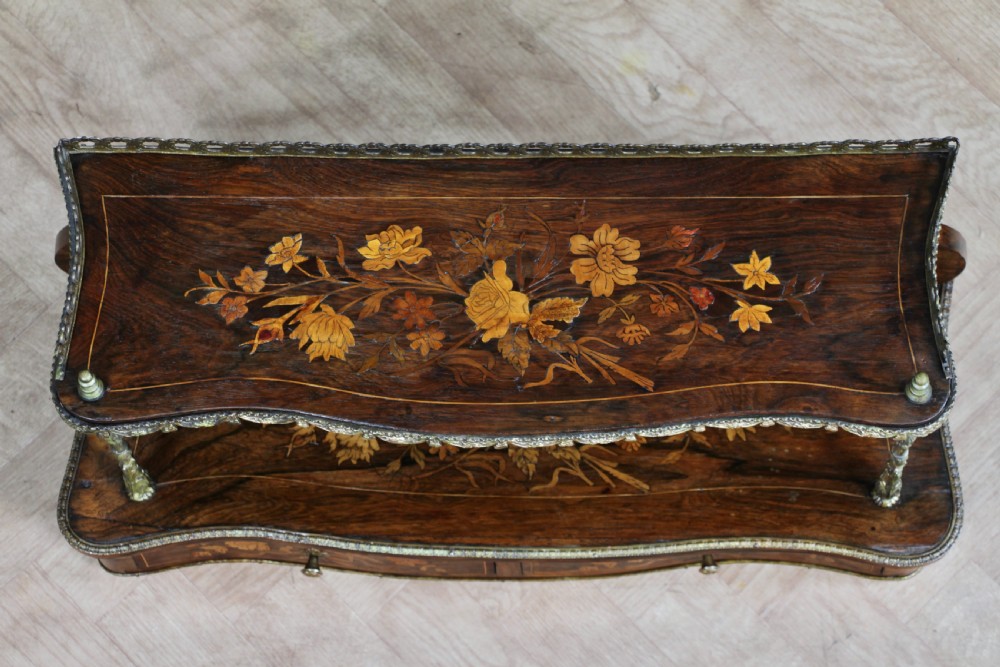 A French Napoleon III rosewood tabletop etagere featuring two tiered shelves decorated with floral marquetry, gilt metal mounts, a gallery rail, and two small base drawers. View XXI