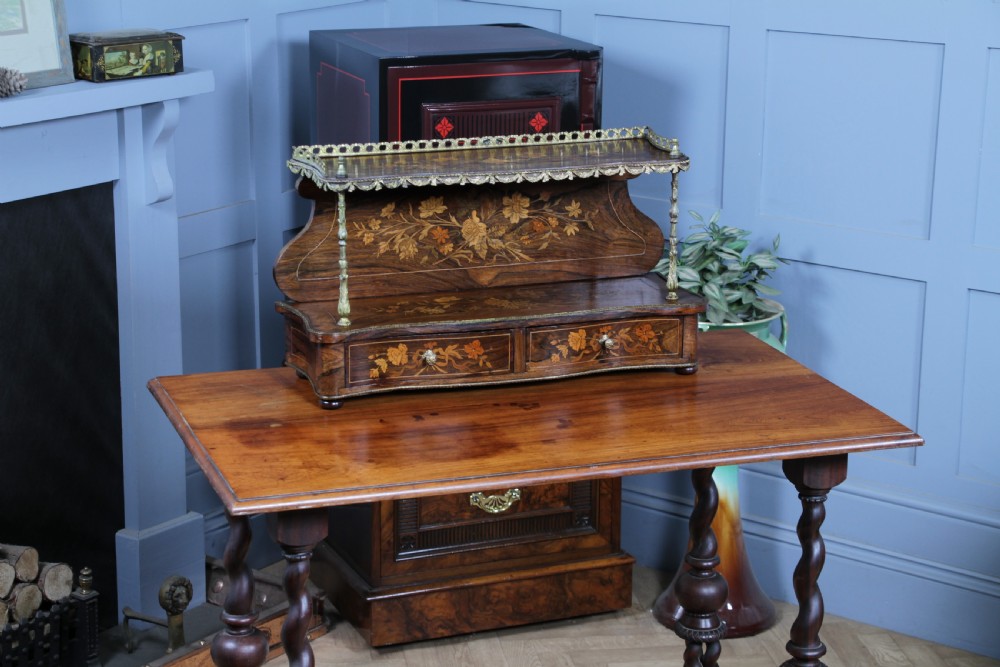 A French Napoleon III rosewood tabletop etagere featuring two tiered shelves decorated with floral marquetry, gilt metal mounts, a gallery rail, and two small base drawers. View XXII