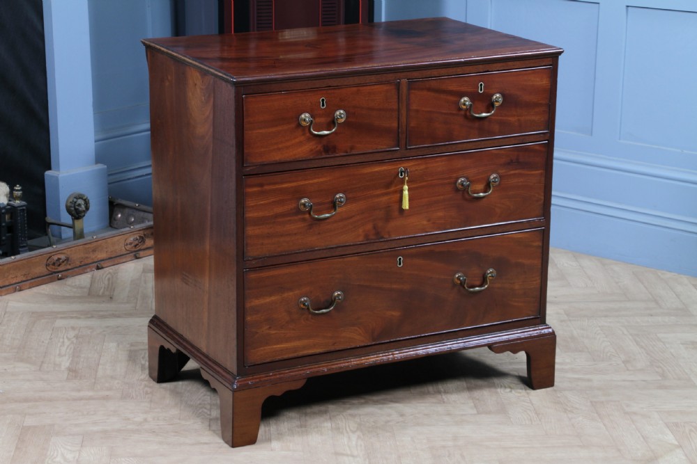 An eighteenth-century Georgian mahogany chest of drawers featuring four drawers with brass swan-neck handles and bracket feet.