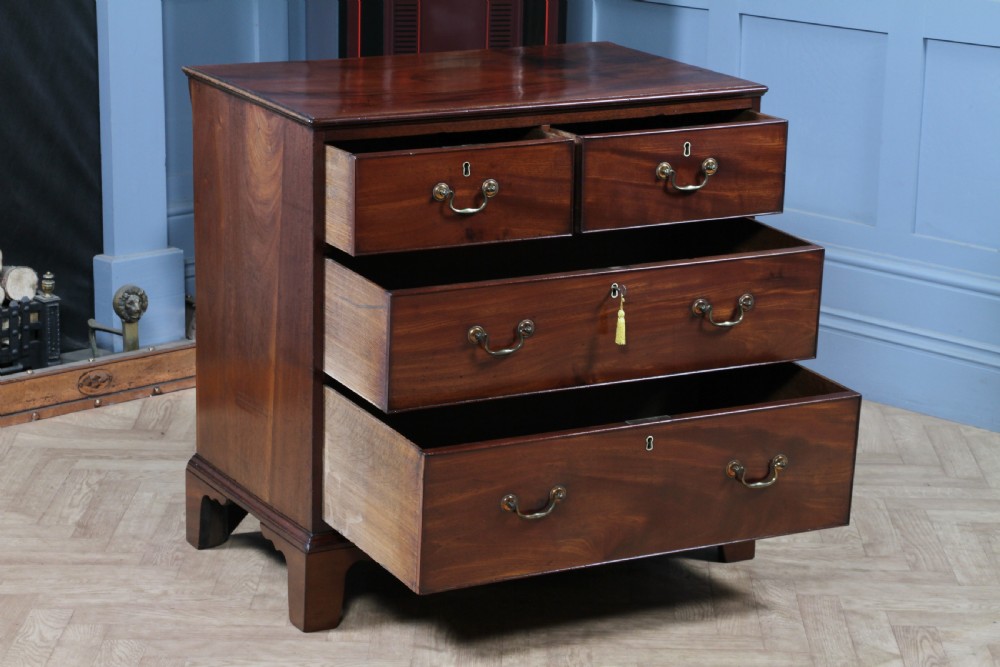 An eighteenth-century Georgian mahogany chest of drawers featuring four drawers with brass swan-neck handles and bracket feet. View II