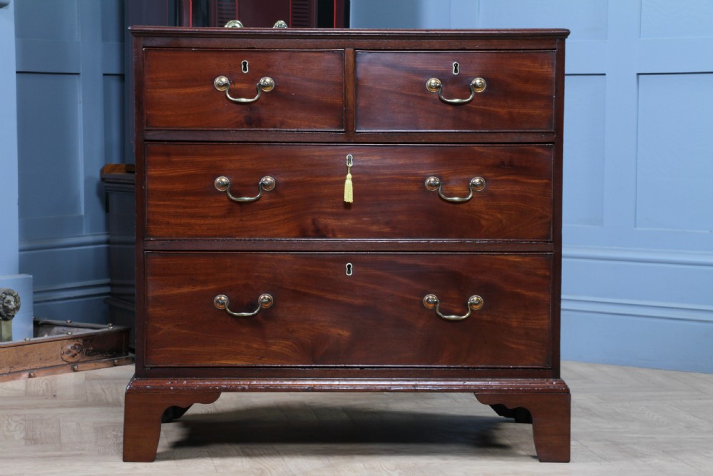An eighteenth-century Georgian mahogany chest of drawers featuring four drawers with brass swan-neck handles and bracket feet. View V