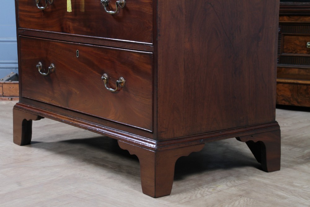An eighteenth-century Georgian mahogany chest of drawers featuring four drawers with brass swan-neck handles and bracket feet. View VI